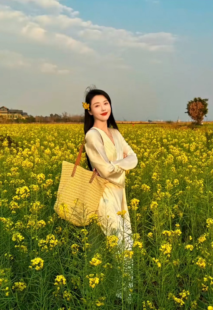 Đứng giữa vườn hoa với túi cói