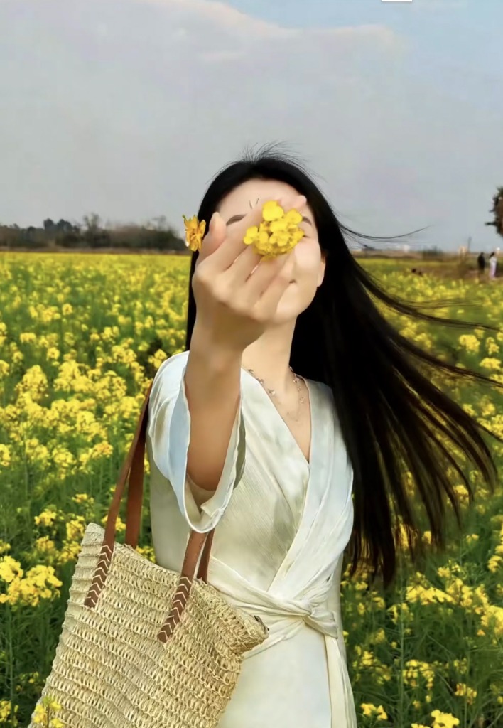 Dùng bông hoa che một phần gương mặt